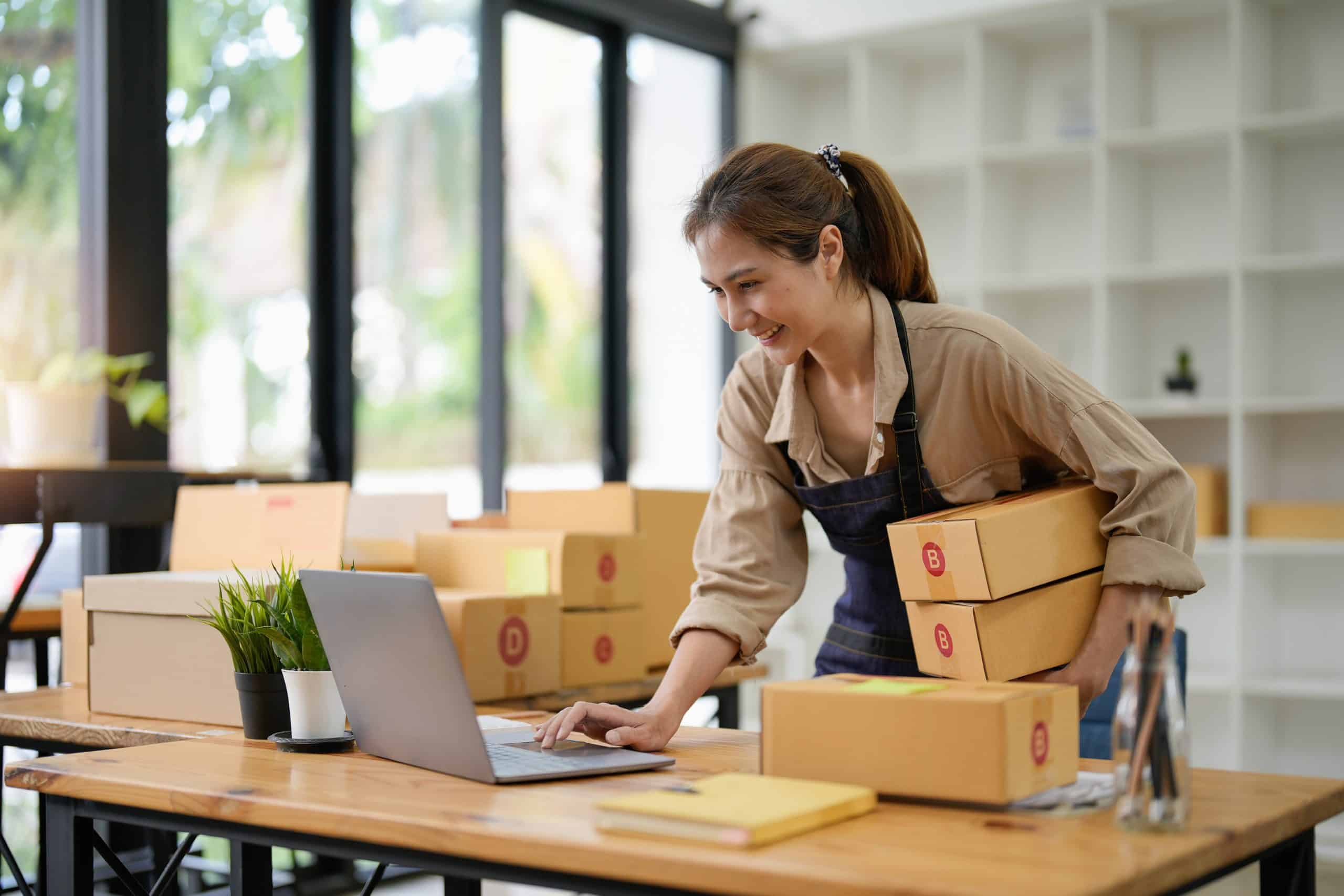 SME entrepreneur Small business entrepreneurs Online selling ideas,Happy Young Asian business owner work on computer and a boxs at home,delivery SME procurement package box deliver to customers,